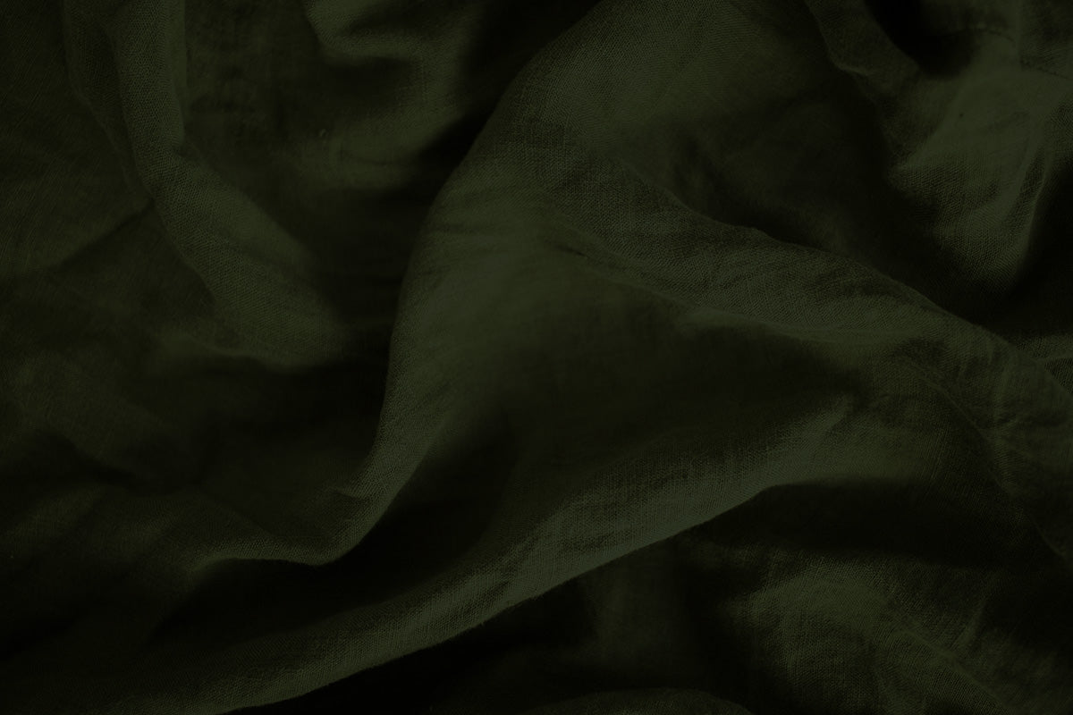 Close-up of soft green linen fabric, symbolizing the simple, versatile foundation of the Essentials collection by Fabled Fox Clothiers.