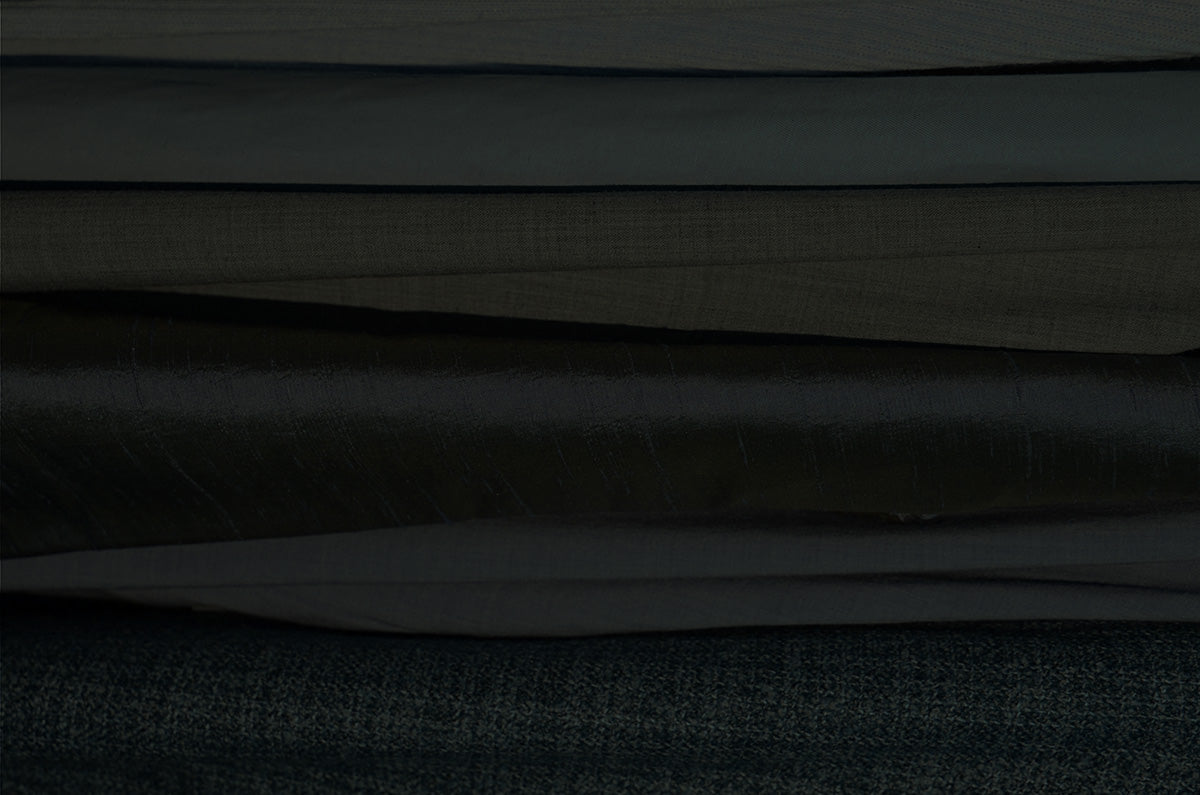 Assortment of different textured fabrics, representing the unique, upcycled craftsmanship of the Relics collection by Fabled Fox Clothiers.